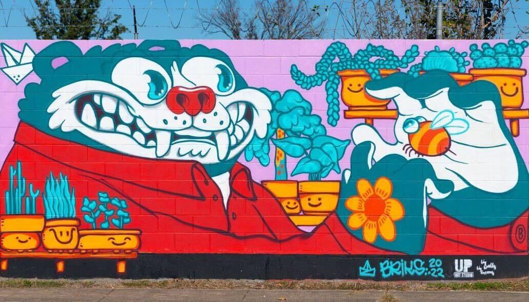 Mural of an animated character with a bee in his hand along the outer wall of the Kashmere bus operating facility at 5700 Eastex Freeway in Houston